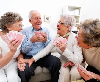 A group of happy elderly people enjoying themselves over a card game